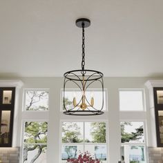 a chandelier hangs from the ceiling above a dining table in front of large windows