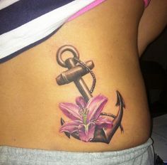 an anchor and pink flower tattoo on the side of a woman's stomach,