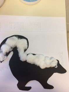 an animal made out of cotton sitting on top of a piece of paper