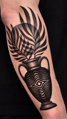 a man's arm with a vase tattoo on it