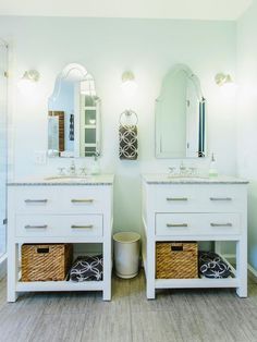 a bathroom with two sinks, mirrors and baskets on the counter top next to each other