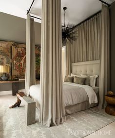 a bedroom with four poster bed and drapes hanging from the ceiling over it's headboard