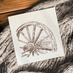 a piece of paper with a drawing of a spinning wheel on it next to some yarn