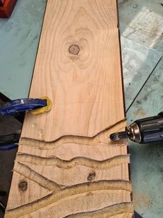 a piece of wood that has been cut in half and is being worked on with a drill