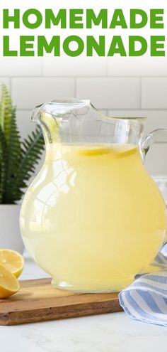 a glass pitcher filled with lemonade sitting on top of a wooden cutting board