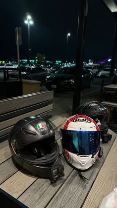 two helmets sitting on top of a wooden bench