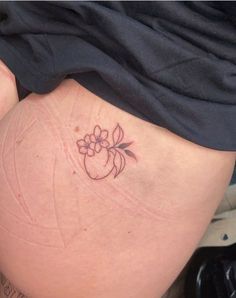 a woman's thigh with a flower tattoo on it