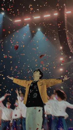 a man standing on top of a stage surrounded by confetti