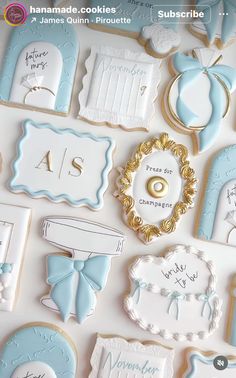 cookies decorated with blue and white icing are arranged on a table top for a baby's first birthday party