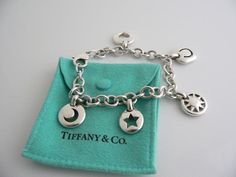 Offered for sale is a gorgeous vintage Tiffany & Co. Sterling Silver 5 Stencil Charm bracelet.  Very substantial and unique Tiffany piece that you will get your money's value for.  It is a wonderful piece that looks very contemporary, chic and cool. The bracelet is made from bright, substantial and solid Tiffany silver - with 5 gorgeous Stenciled Silver Charms dangling from it - a stenciled horseshoe, a beautiful sun charm, a moon charm, a star charm, and a heart charm. The piece looks gr Tiffany Charm Bracelet, Tiffany Co Bracelets, Horseshoe Bracelet, Pandora Bracelet Charms Ideas, Tiffany And Co Bracelet, Star Bangle, Tiffany And Co Jewelry, Sun Charm, Vintage Tiffany