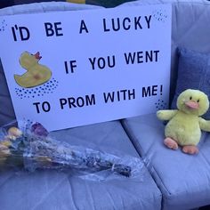 a stuffed duck sitting next to a sign that says i'd be a lucky if you went to prom with me