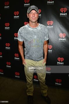 a man in grey shirt and khaki pants standing next to a heart wall