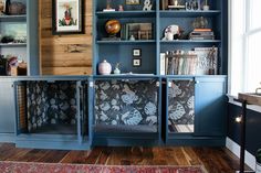 a living room with blue bookcases and pictures on the wall behind them,