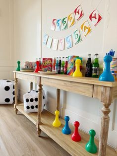 a wooden table topped with lots of different colored game pieces and games on top of it