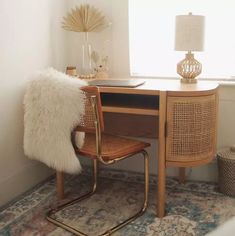 a desk with a chair and lamp next to it