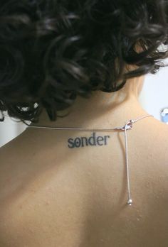 the back of a woman's neck with an inscription on it that reads, sonder