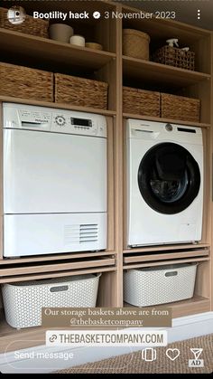 two washers and dryer sitting in front of wooden shelves with baskets on them