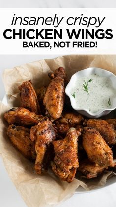 chicken wings in a basket with ranch dressing on the side and text overlay that reads instant crispy chicken wings baked, not fried