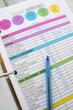 a blue pen sitting on top of a binder next to a calculator