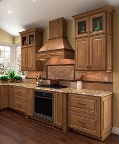 a large kitchen with wooden cabinets and granite counter tops, along with wood flooring