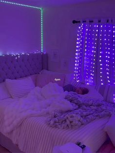 a person laying on a bed in a room with purple lights