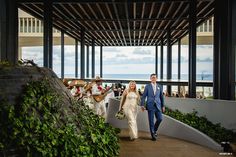 the bride and groom are walking down the stairs to their wedding reception at the beach