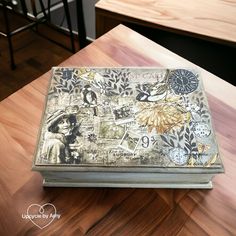 a wooden table topped with a metal box covered in pictures