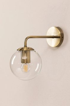 a wall light that is on the side of a wall with a clear glass ball