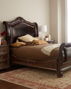 a bedroom with a bed, dresser and window in the corner next to an area rug