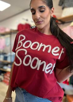 Get ready to cheer on your team in style with our Boomer Sooner Crimson Stadium Oversized Tee! This not-so-basic crimson short sleeve tee is a fashionable dupe of Free People and features Boomer Sooner in cream metallic stitching. Perfect for game day and for all your Saturdays in Norman. Boomer Sooner! *NCAA Licensed Trendy Game Day T-shirt With Short Sleeves, Summer Fan Gear Graphic Tee Tops, Summer Fan Gear Graphic Tee, Summer Graphic Tee Tops For Fans, Team Name T-shirt For Game Day In Summer, Summer Game Day T-shirt With Team Name, Sports Fan Crew Neck T-shirt For Summer, Sports Fan Summer Crew Neck T-shirt, Summer Sports Fan T-shirt With Crew Neck