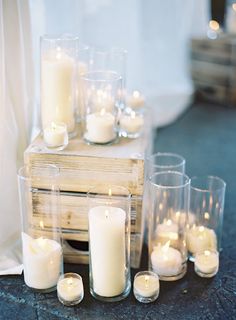 white candles are arranged on a wooden box