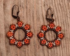 these earrings are characterized by a circular shape that recalls the shape of flowers. The main colour is orange and from here the name sunset flower Orange Beaded Flower Earrings, Orange Flower-shaped Earrings For Gift, Handmade Red Flower Earrings, Handmade Orange Flower Earrings, Handmade Orange Flower-shaped Jewelry, Orange Circular Jewelry As A Gift, Red Round Flower Earrings With Ear Wire, Handmade Orange Flower Shaped Earrings, Rust-colored Earrings For Gift