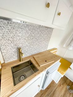 a kitchen sink and counter top in a small room with wood flooring on the walls