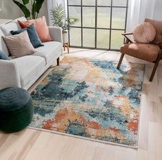 a living room with a couch, chair and rug in front of a large window