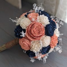 a bridal bouquet with coral, navy and white flowers