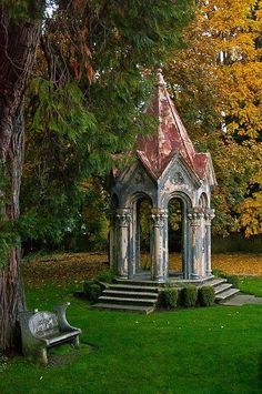 an old stone gazebo in the middle of a grassy area with steps leading up to it