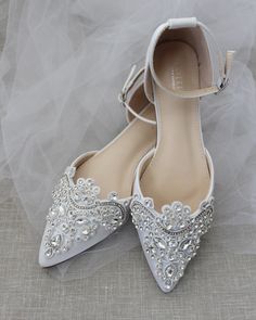 a pair of white wedding shoes with crystal embellishments