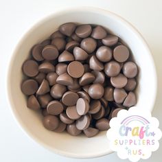 a white bowl filled with chocolate candies next to a rainbow sticker that says craft supplies