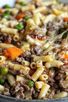 a bowl filled with pasta and vegetables on top of a table