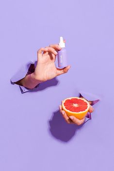 a person holding a grapefruit and an orange in their hand with a lot of deodorant on it