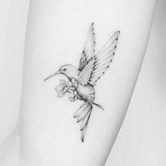 a small tattoo of a hummingbird with flowers