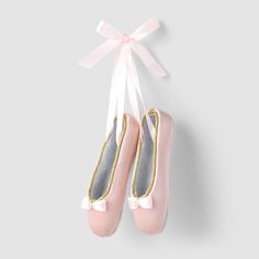 two pink ballet shoes hanging from a string