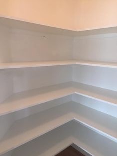 empty white shelves in the corner of a room