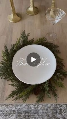 a white plate sitting on top of a wooden table next to wine glasses and candles