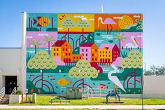 a large mural painted on the side of a building with trees and buildings in it