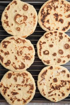 four pita breads sitting on top of a grill