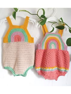 two crocheted swimsuits hanging on a wall next to a potted plant