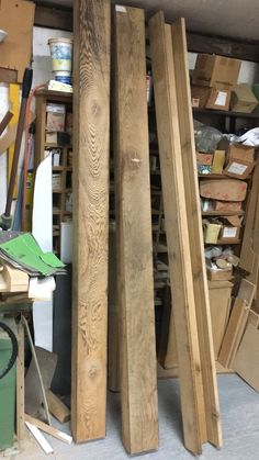 several wooden boards stacked on top of each other in a room with boxes and tools