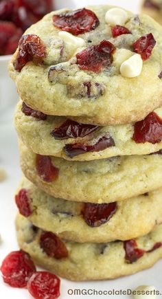 a stack of cookies with cranberries and white chocolate chips