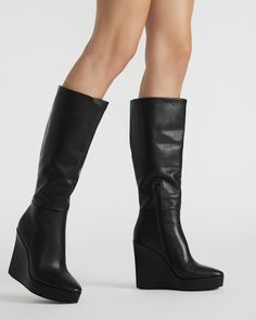 The AKIRA knee-high boot features a platform wedge design and a convenient inside zipper for easy on and off. Elevate your style game with this versatile and stylish boot, perfect for any occasion. 4.5 inch heel height Size 6 measurements: 14 inch shaft circumference, 13.75 inch shaft height Size 8 measurements: 15 inch shaft circumference, 14.75 inch shaft height Size 10 measurements: 16 inch shaft circumference, 15.75 inch shaft height Leather upper material Textile lining Synthetic sock Synth Platform Slip Ons, Knee High Platform Boots, Platform Boots Women, Summer Wardrobe Staples, Stylish Boots, 5 Inch Heels, Platform Wedge, Black Leather Boots, Platform Boots